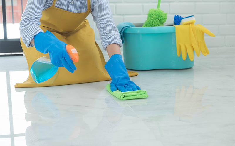 Person cleaning stains from a shiny marble floor